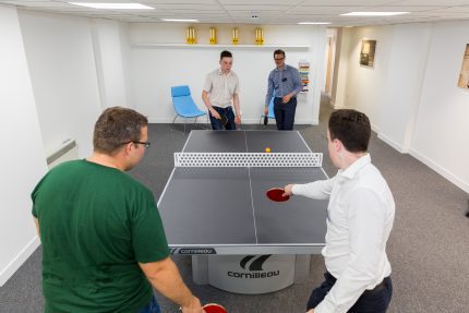Co-workers playing table tennis